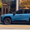 A blue 2023 Toyota RAV4 Hybrid small SUV is driving on the road.