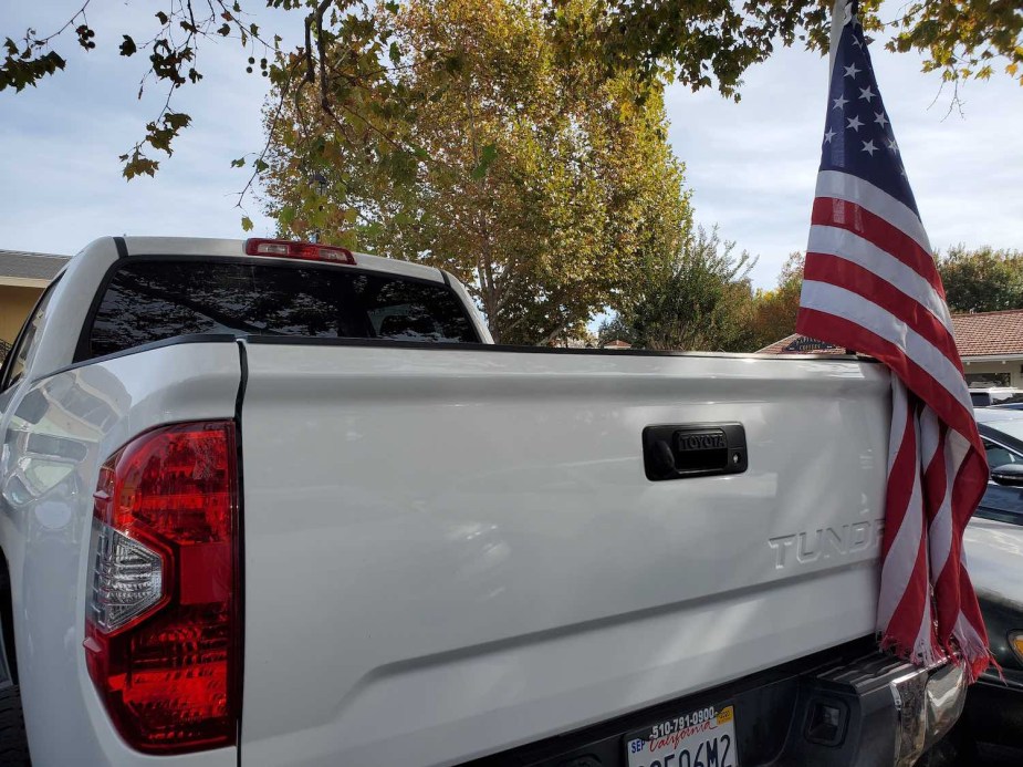 Toyota Tundra pickup truck with a U.S.A. flag flying from its bed.