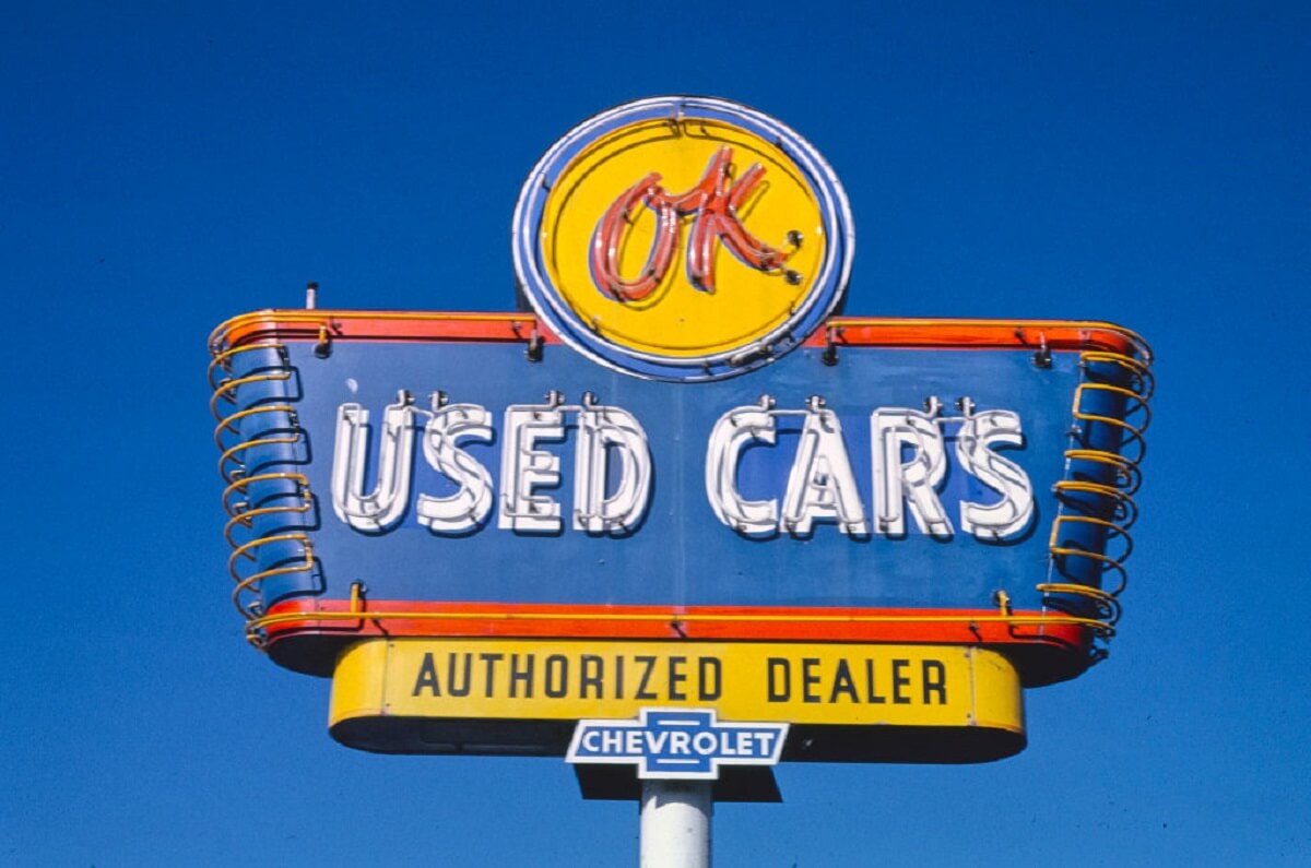 A cheap used car lot shows off its classic signage.