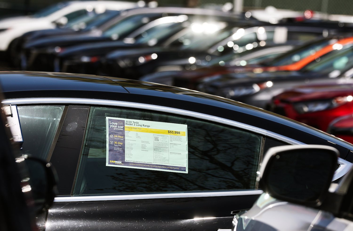 The window sticker in a used Tesla Model 3 electric car for sale on a dealer lot.