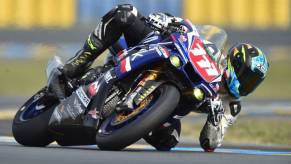 A motorcycle racer taking a sharp turn on a Yamaha R1.