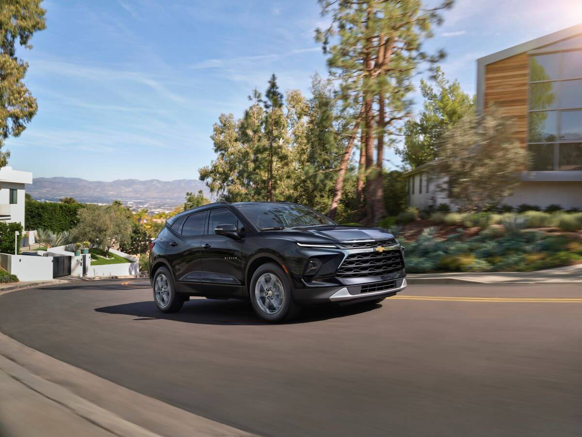 A 2024 Chevy Blazer 3LT midsize SUV model driving up a suburban hill