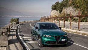 A 2024 Alfa Romeo Tonale PHEV model driving on a seaside highway road