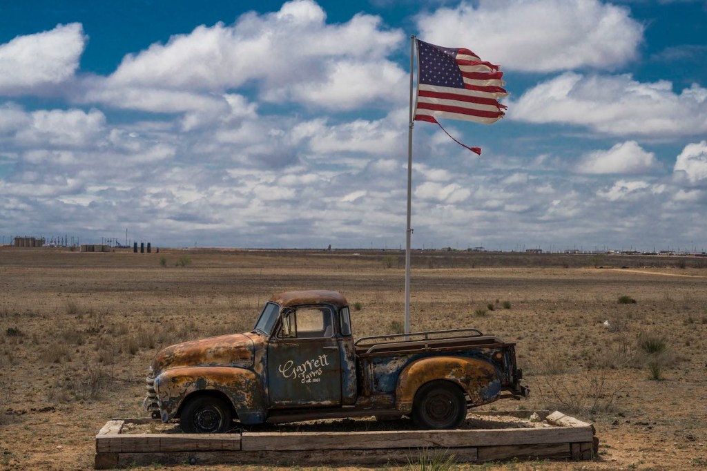 Classic pickup truck flying the U.S.A. flag from its bed.