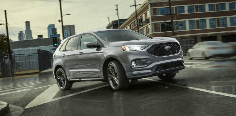 A 2024 Ford Edge midsize SUV driving through an overcast city crosswalk