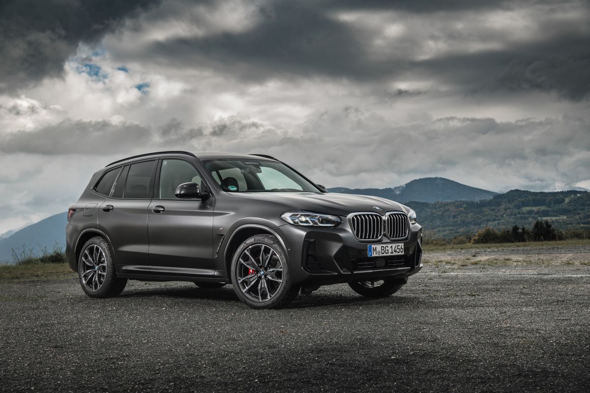 A BMW X3 compact luxury SUV model with the xDrive30d trim configuration parked on gravel under an overcast sky