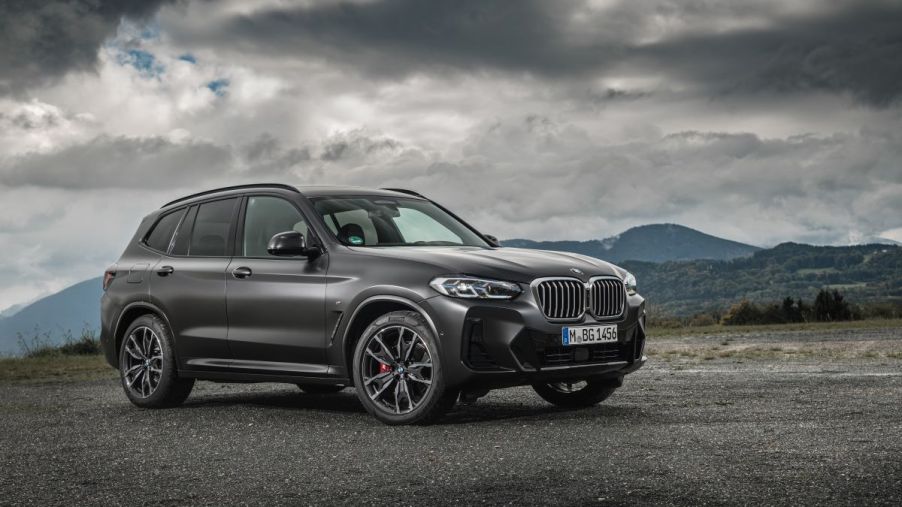 A BMW X3 compact luxury SUV model with the xDrive30d trim configuration parked on gravel under an overcast sky