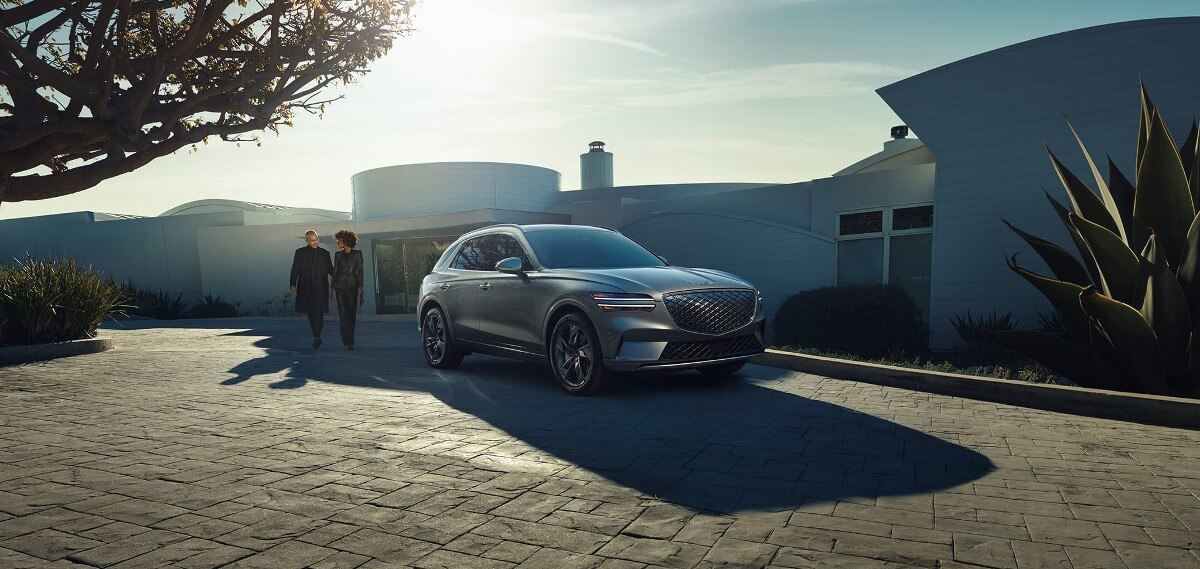 A 2024 Genesis Electrified GV70 all-electric compact luxury SUV model parked on a a tile plaza
