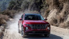 A 2024 Hyundai Tucson compact SUV model driving on a gravel dirt off-road trail
