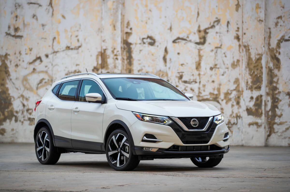 A 2022 Nissan Rogue Sport compact crossover SUV model parked in front of a peeling wall