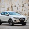 A 2022 Nissan Rogue Sport compact crossover SUV model parked in front of a peeling wall