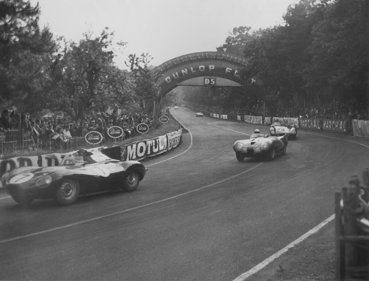 A set of race cars take a corner at Le Mans.
