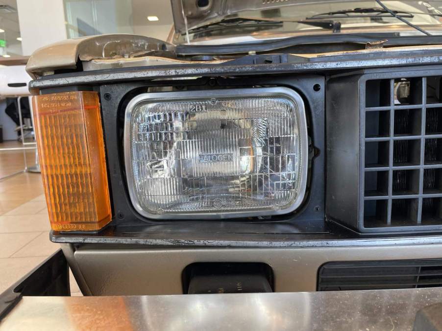 The headlight of a VW Rabbit pickup truck on the Cars & Bids website.