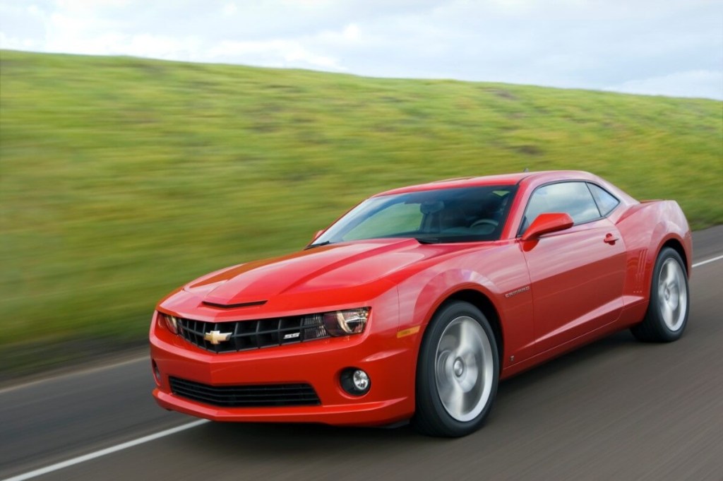 A bright-red 2010 Chevrolet Camaro SS blasts down a back road.