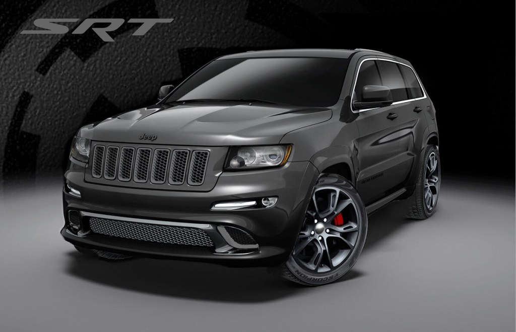 A dark-gray 2013 Jeep Grand Cherokee SRT8 poses in front of an SRT graphic.