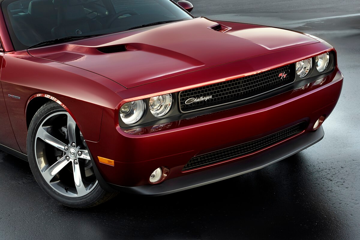 A dark-red 2014 Dodge Challenger R/T shows off its classic badging and round headlamps.