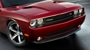 A dark-red 2014 Dodge Challenger R/T shows off its classic badging and round headlamps.