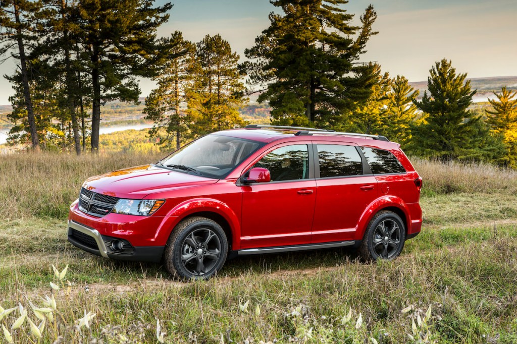 A red Dodge Journey in a field