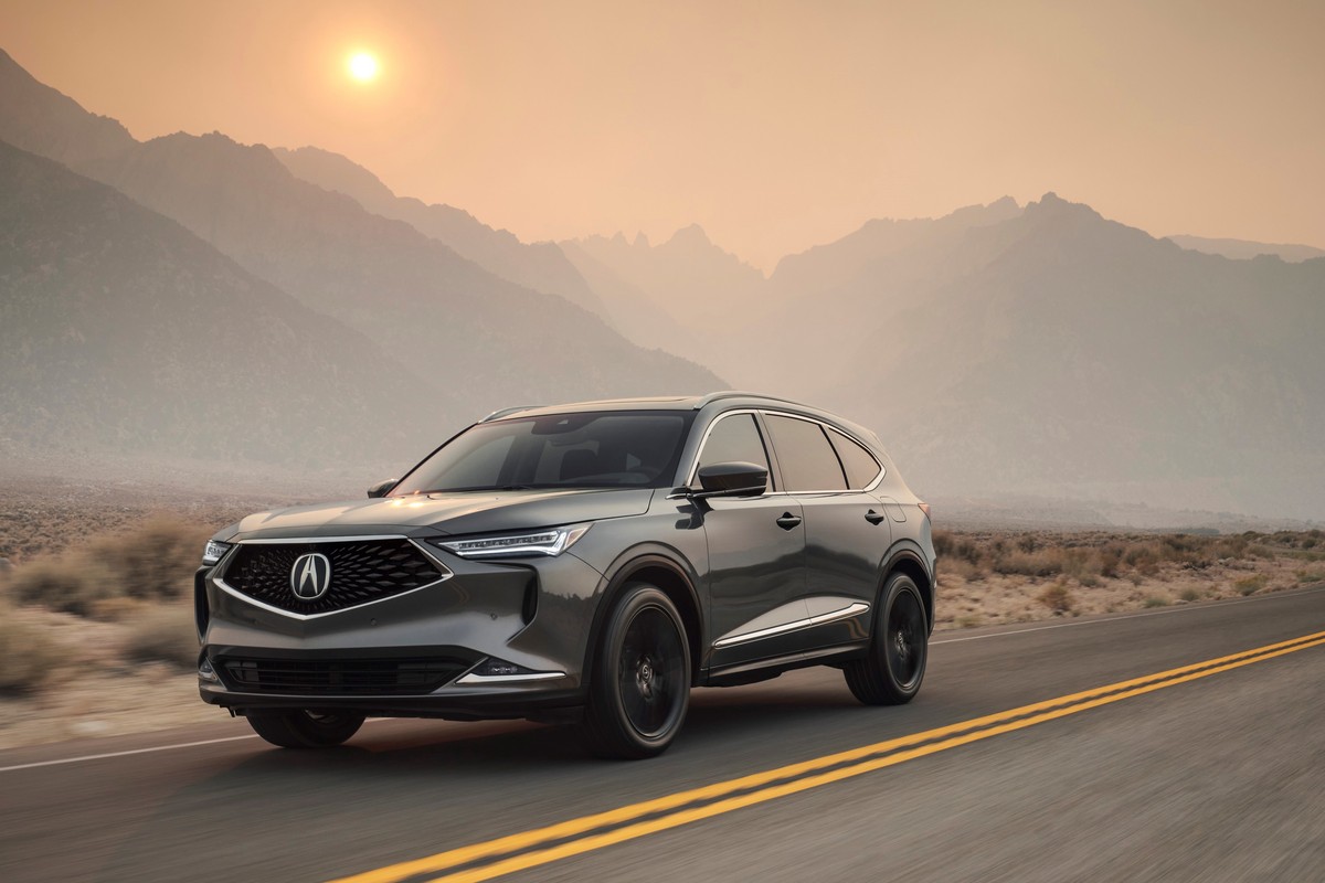 A 2023 Acura RDX driving down an open road.