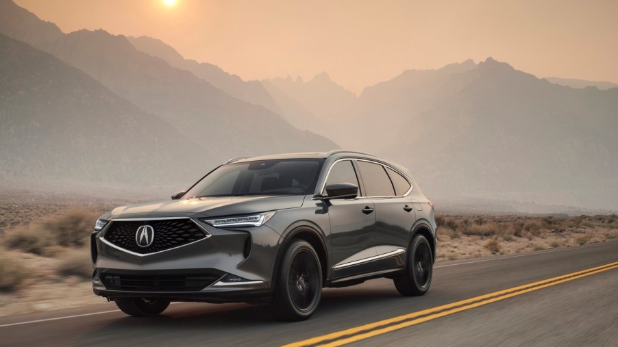 A 2023 Acura RDX driving down an open road.