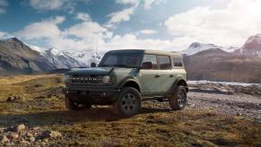 A green 2023 Ford Bronco parked in front of mountains. Bronco sales aren't where they should be.