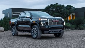 A black 2023 GMC Canyon Denali on display in front of a residence. GMC Canyon owners don't seem to love the interior as much as you'd expect.