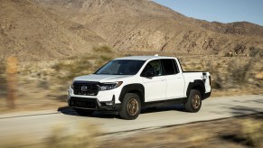 A white 2023 Honda Ridgeline driving in the desert. Honda Ridgeline sales should be higher than what they are.