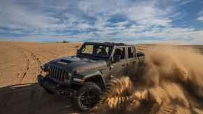A 2023 Jeep Gladiator driving in some sand.