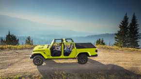 2023 Jeep Gladiator pickup truck parked on a mountain road with its top down.