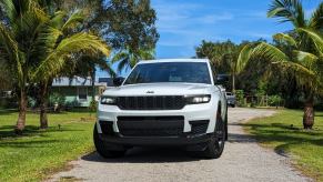 A white 2023 Jeep Grand Cherokee L midsize three-row SUV is parked in a driveway.