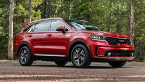 A red 2023 Kia Sorento Hybrid midsize hybrid SUV is parked outdoors.