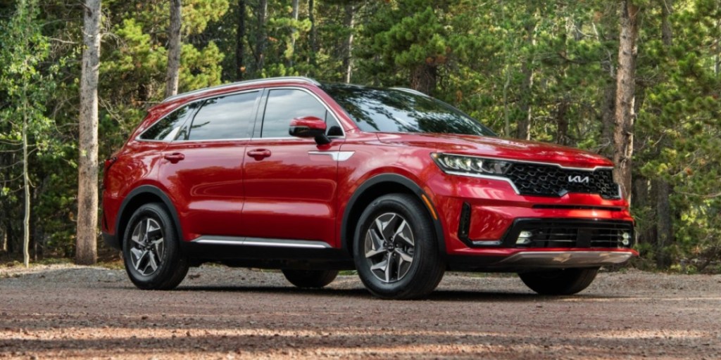 A red 2023 Kia Sorento Hybrid midsize hybrid SUV is fuel-efficient and cost-saving.