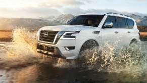 A white 2023 Nissan Armada full-size SUV is driving off-road.