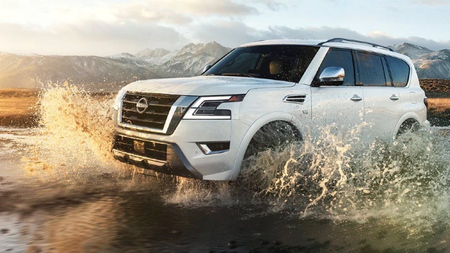 A white 2023 Nissan Armada full-size SUV is driving off-road.