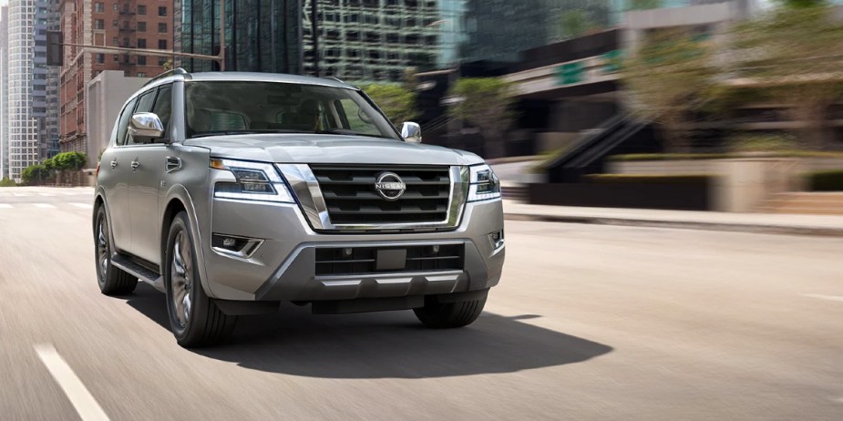A gray 2023 Nissan Armada full-size SUV is driving on the road. 