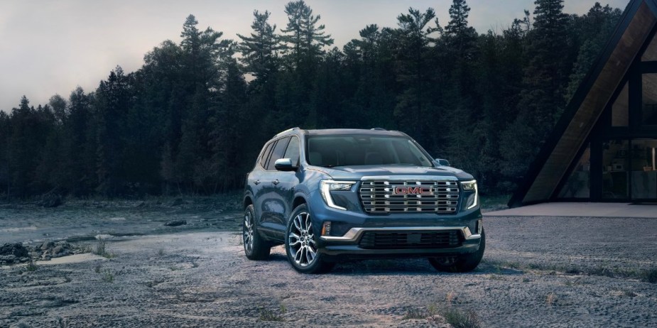 A blue 2024 GMC Acadia midsize three-row SUV is parked outdoors, can it dethrone the Kia Telluride?