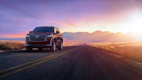 2024 Cadillac Escalade Premium Luxury in Mahogany Metallic on highway. Cadillac Escalade sales are on the rise