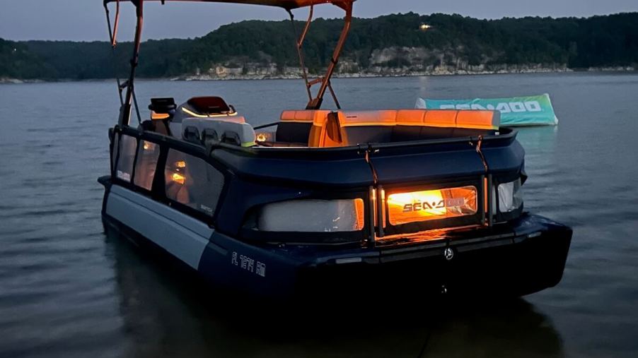 A 2024 Sea-Doo Switch Cruise Limited shows off its orange lighting at night.