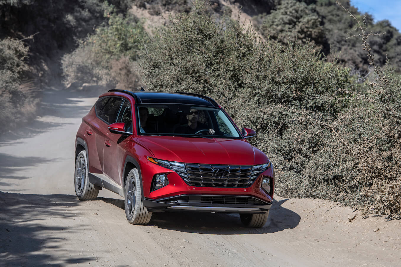 A red 2024 Hyundai Tucson driving down a mountain path. Hyundai manufacturing should impact growth for the Tucson
