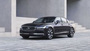 A 2024 Volvo S90 Recharge executive sedan model parked on gray tiles near rows of stone stairs