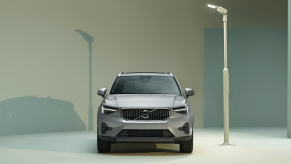 A front-facing 2024 Volvo XC40 subcompact luxury SUV model illuminated under a streetlight lamppost