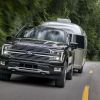 The 2024 Ford F-150 Hybrid pulling a camper on the road