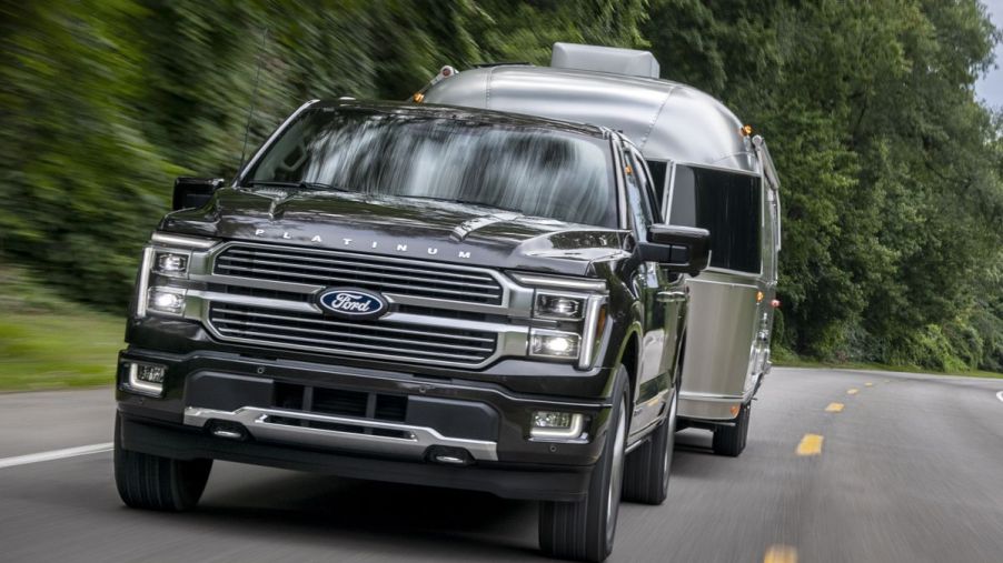 The 2024 Ford F-150 Hybrid pulling a camper on the road