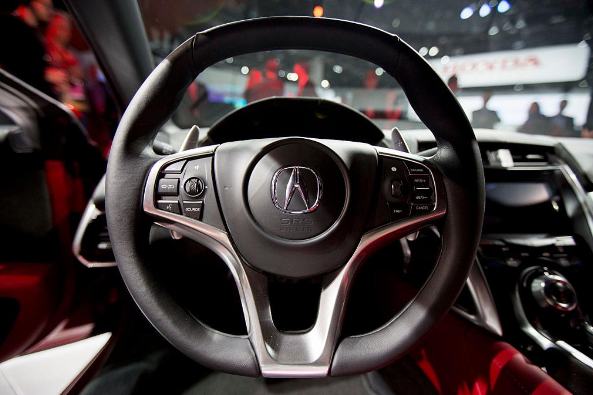 An Acura logo on a steering wheel. Acura is moving away from hybrid models.