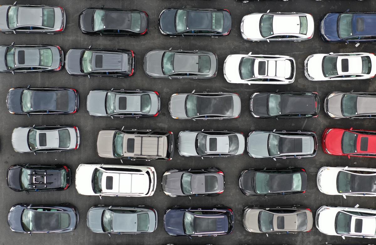 A birds-eye view of new cars at a dealership.