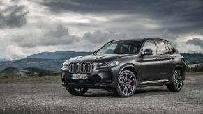 A BMW X3 xDrive30d compact luxury SUV model parked on a gravel plain under darkening clouds