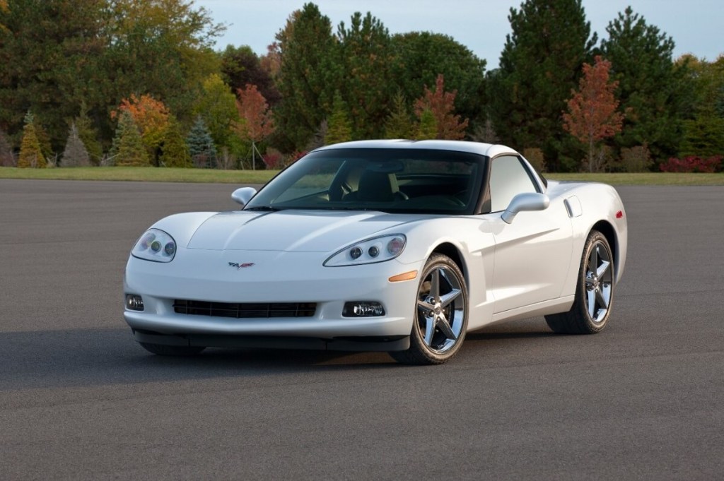 A white C6 Coupe parks in a large lot.