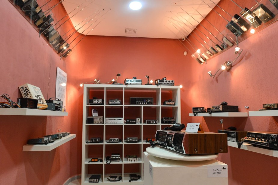 CB radio handsets, household sets, and car and truck sets on the shelves of a museum.