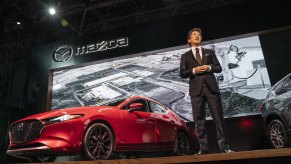 Masahiro Moro, CEO of Mazda Motor of America Inc., speaks while standing in front of a Mazda Motor Corp. 3 AWD sedan during the 2019 New York International Auto Show