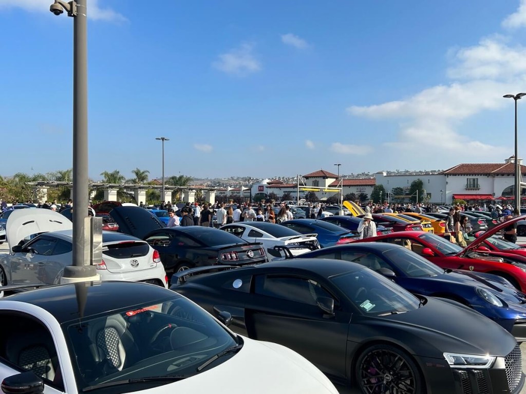 Crowds move about at the South OC Cars and Coffee in San Clemente.
